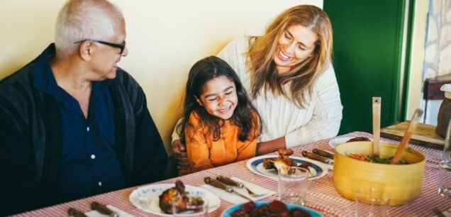 Happy,Grandparents,Eating,With,Grand-daughter,At,Home,Patio,-,Soft